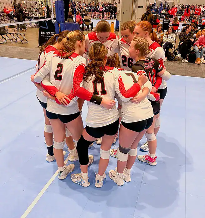 Alabama Juniors Volleyball Club players huddle during an indoor volleyball tournament.